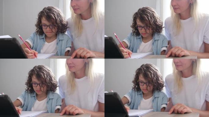 Mother and small son eyeglasses study online on ta