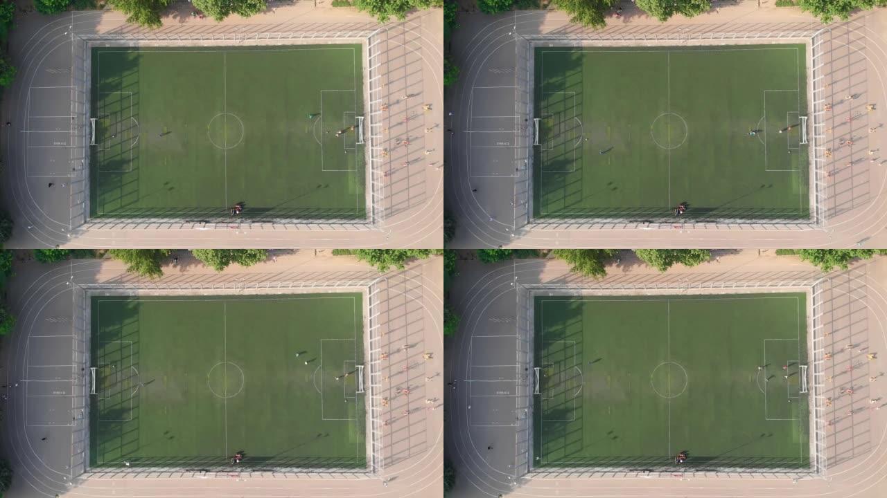 当地孩子在学校体育场操场踢足球和训练足球。鸟瞰图