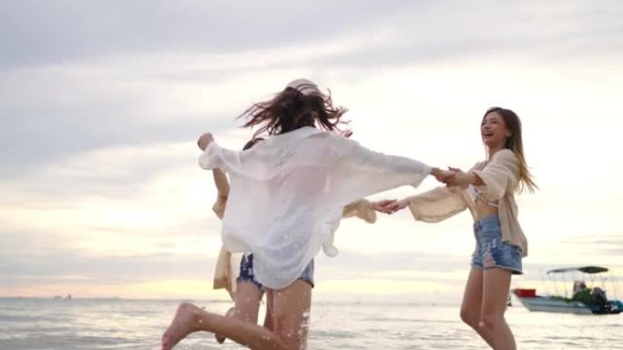 4k组亚洲女性朋友在夏季日落时在热带岛屿海滩上一起玩。