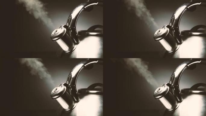 沸腾的钢制银水壶，带有黑色背景上的蒸汽特写哨子。具有速度斜坡效果的4k原始慢动作视频。在高速电影摄像