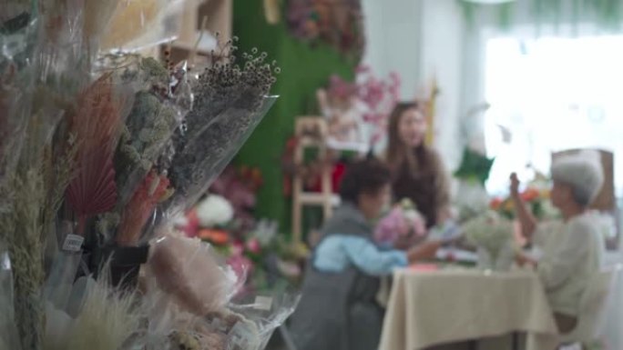 亚洲中国女花店教她的高年级学生插花的配色概念