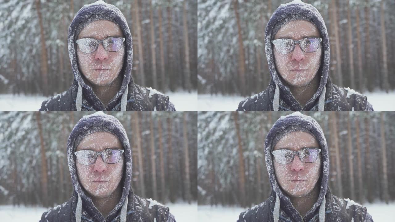 冬日森林里一个戴着眼镜的冻僵男子，在一场暴风雪过后，满身是雪，面带微笑地看着镜头…