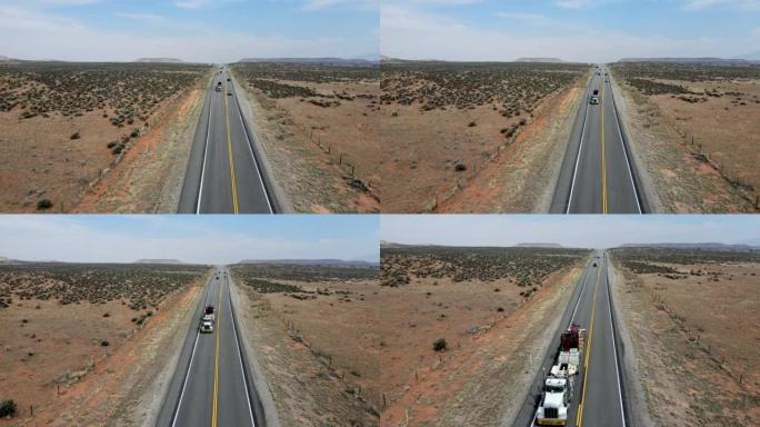 无人机视图半卡车在摩押附近的犹他州西南部红岩砂岩地区沙漠中的四车道高速公路上超速行驶