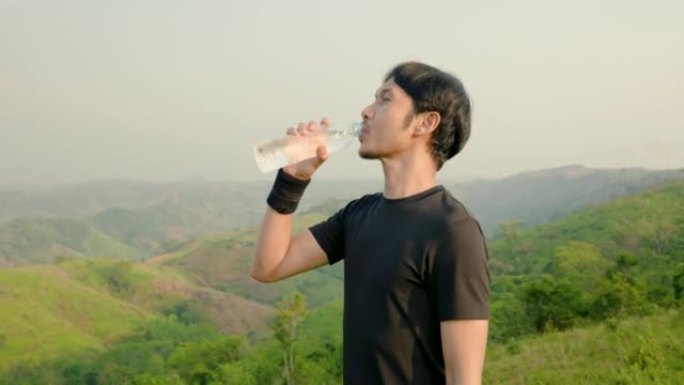 4K 50fps，亚洲越野跑者休息。高山上有美丽的风景。提起水瓶和饮料，使运动精疲力尽。