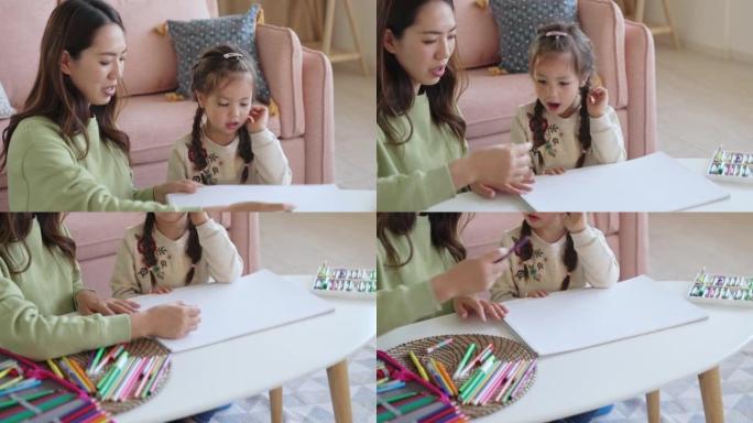 可爱的小女孩和妈妈一起在家画画