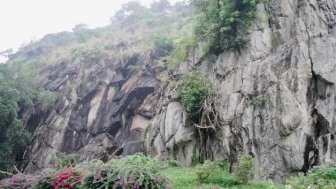 黑暗的陈旧破旧的悬崖面，并被巨大的裂缝和层分开。粗糙，粗糙的灰色石头或岩石纹理的山脉，背景和复制空间