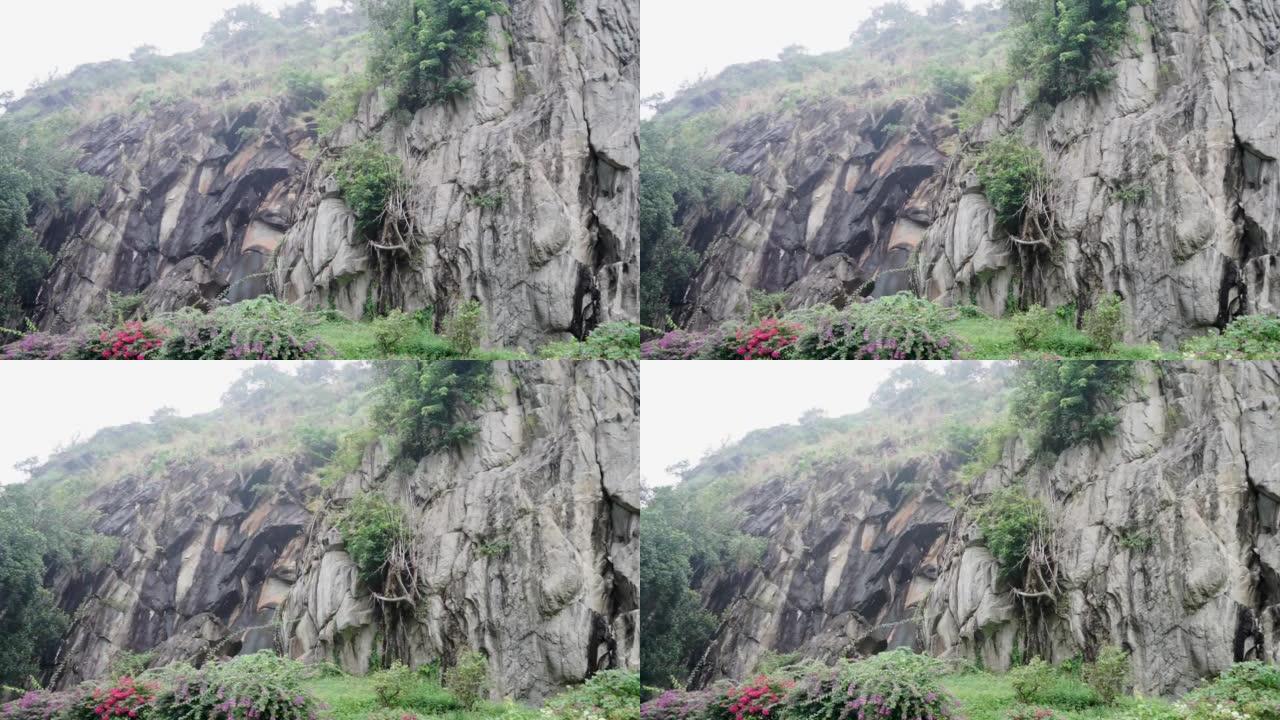 黑暗的陈旧破旧的悬崖面，并被巨大的裂缝和层分开。粗糙，粗糙的灰色石头或岩石纹理的山脉，背景和复制空间