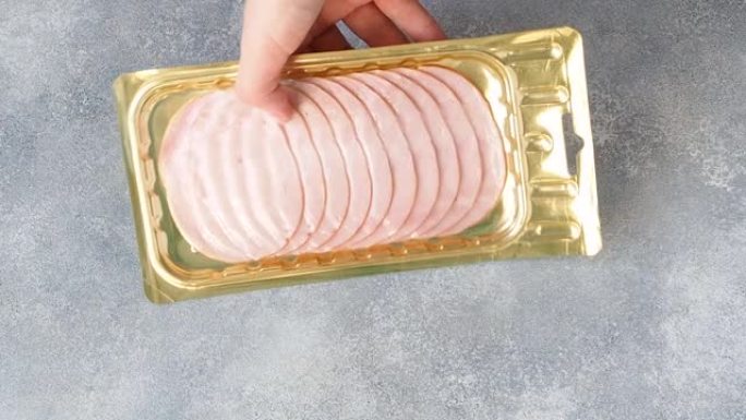 将薄薄的猪肉火腿放在桌子上的真空包装中。肉片碳酸盐包装，可长期储存