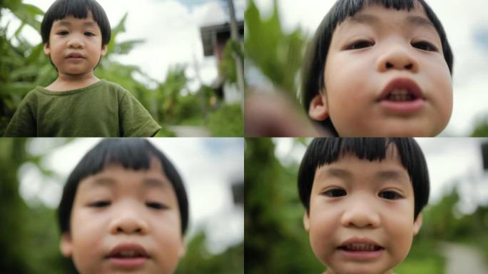 带着花在家庭花园里玩耍和奔跑的小孩的快乐时刻。亚洲男孩热爱和关心环境。一个有着美丽天性的孩子的微笑。