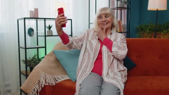 快乐的老奶奶拿着智能手机看手机视频在线自拍回家