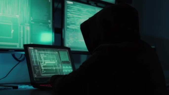 一名黑客程序员穿着连帽衫，戴着黑色黑客面具，隐藏自己的身份，利用电脑进行黑客活动。这就是黑暗网络的概