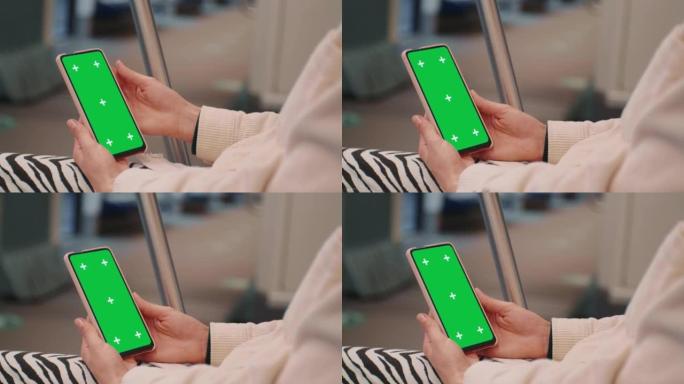 在地铁上使用带有绿屏模拟显示的智能手机的女性双手。