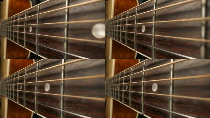 相机在古典原声吉他的指板上平移。棕色木制吉他琴颈与弦乐和品格极端特写。弦乐器。木制原声吉他的一部分