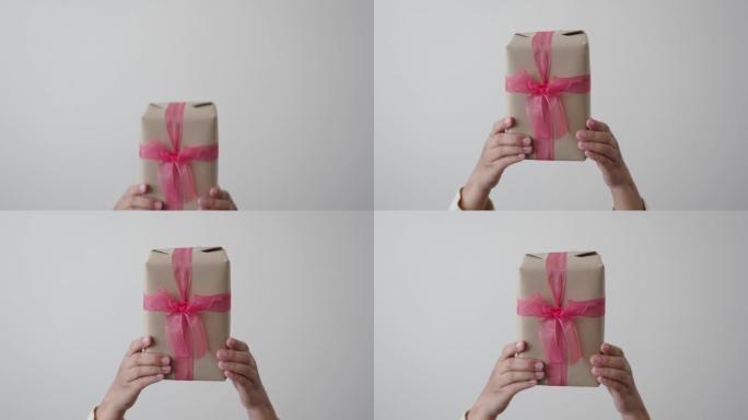 拿着和展示粉色丝带礼品盒的女人