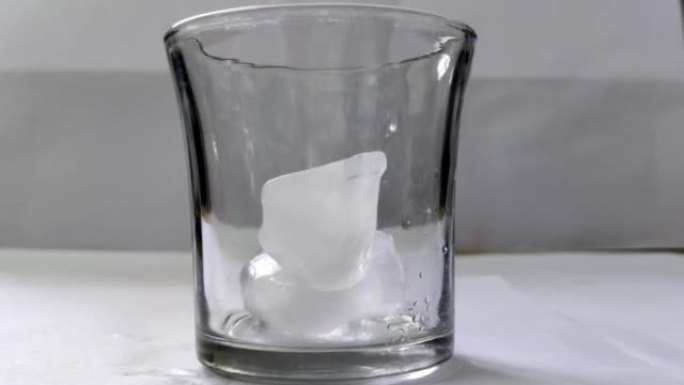 放冰块并装满一杯水的镜头