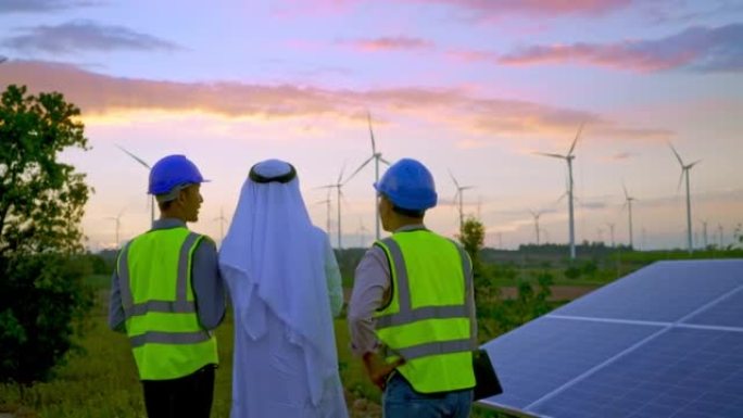 中东阿拉伯商人，工程师，技术人员在风力涡轮机农场检查和维护太阳能光伏板