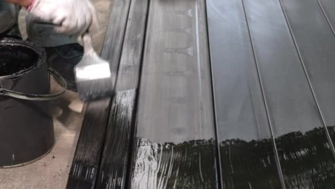 工人在建筑工地油漆钢柱。
