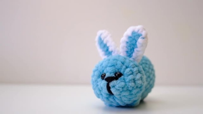 可爱的兔子的钩针玩具。
兔子毛绒玩具蓝绿色。摄像机运动