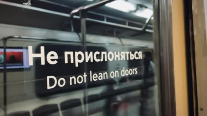 莫斯科: 俄语和英语在门上的文字 “请勿靠在门上”。乘坐4k慢动作的地铁列车。