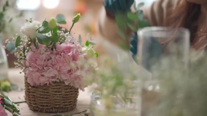 特写亚洲女性中国花店用乳胶手套在篮子里插花