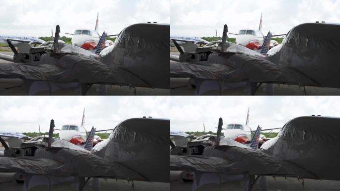 全新的小型双引擎飞机的特写镜头都在机库内其他小型飞机的运输包装中