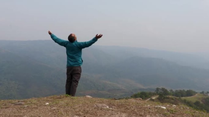 男人在山顶享受大自然，从平面角度看迷雾山脉的愤怒背景