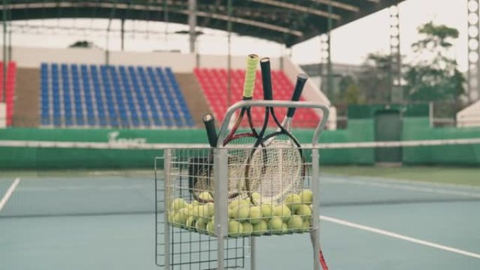 空网球场，配有网球车和球拍。