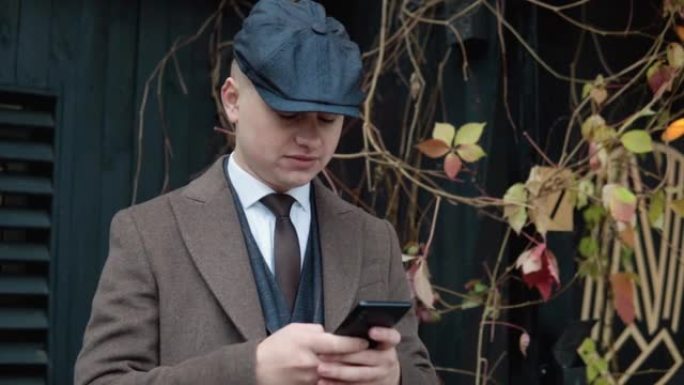 年轻时尚的商人在街上使用智能手机。一个英俊男子在户外打电话的肖像
