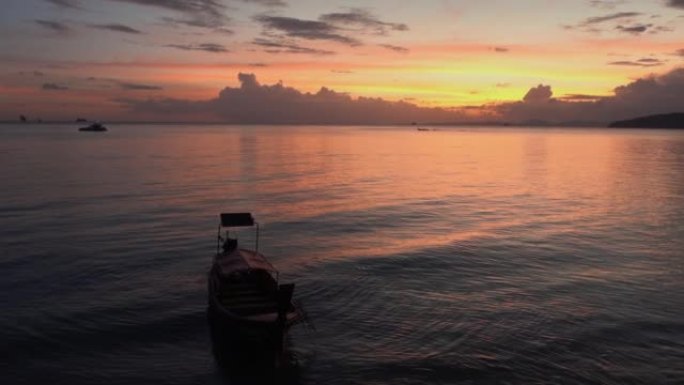 五彩缤纷的亚洲日落，小船。泰国奥南。平静的海景风景晚景