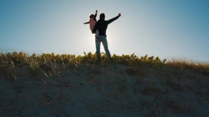 Man plays with kid outdoor on the grass during sun