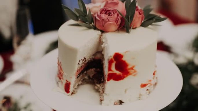蛋糕顶部的特写镜头，盘子上装饰有花朵。一块蛋糕被切掉了