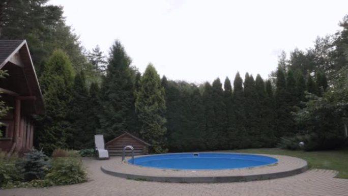 木屋的休闲院子，旁边有游泳池和躺椅。