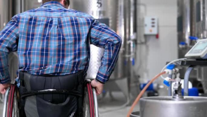 在精酿啤酒工厂使用轮椅工作的残疾人。高质量4k镜头