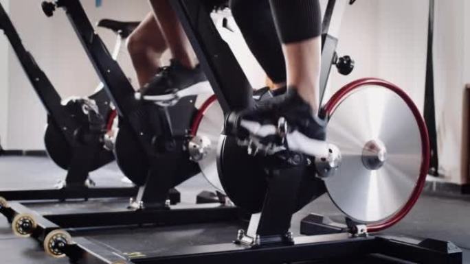 在室内健身馆骑固定自行车的脚慢动作视频