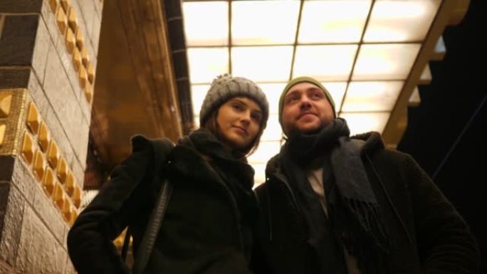 年轻人夫妇在夜间约会时在公交车站等待城市交通