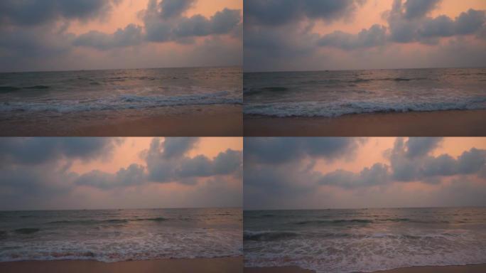印度果阿科尔瓦海滩日落时海浪的广角慢镜头。日落时海面上的云。美丽的海滩日落背景。海滩概念的暑假。