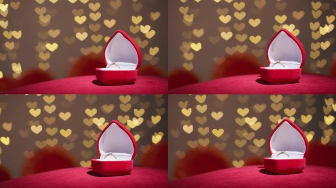 钻石戒指，红色织物背景上有珠宝礼品盒。情人节的金色订婚戒指。结婚求婚的概念。节日和装饰品的浪漫气氛。