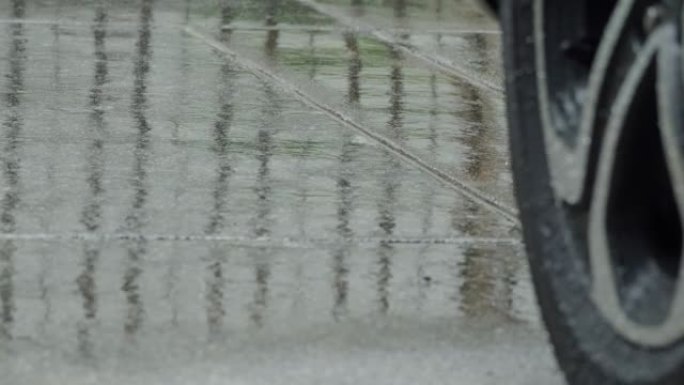 雨水飞溅和汽车轮胎在雨水中。在雨中停车。雨季和潮湿路面上的轮胎。在潮湿的道路上关闭汽车轮胎或车轮。代