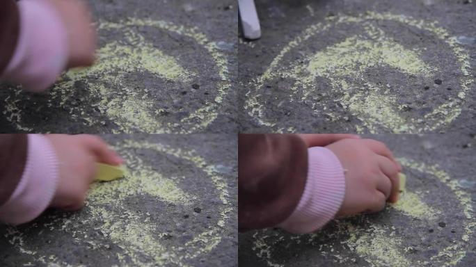 儿童用蜡笔在沥青上画画。儿童在室外的沥青路面上用彩色粉笔画画。童年的概念。儿童做梦