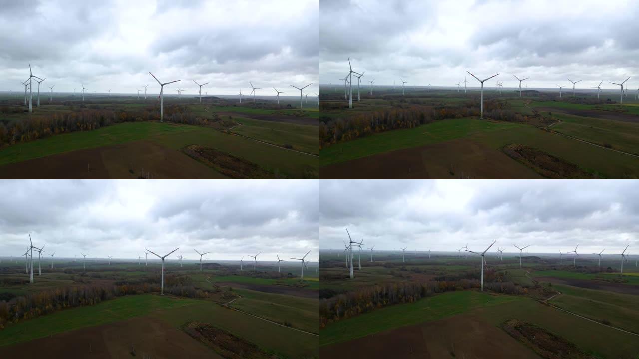 阴天在广大农村地区进行多个旋转风力涡轮机的航拍，用于可再生电力生产