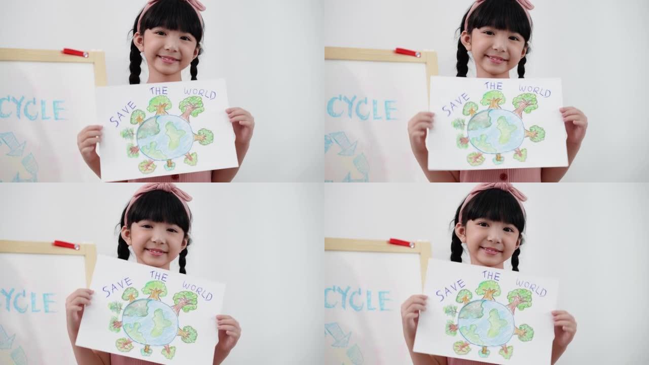 可爱的亚洲六岁女孩在拯救世界的主题中展示并拿着她的画，她画了球形的全球覆盖物，上面覆盖了许多绿色的森