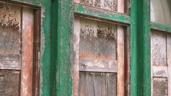 在一栋废弃的乡村建筑中，旧的老式窗户用破裂的胶合板登上。垃圾纹理