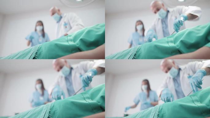 专家外科医生在手术室为病人进行手术。医生和女护士正在治疗一个意外中失去知觉的病人，躺在急诊室的床上。