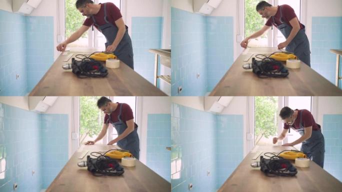 高加索男性木匠正在测量他工作的木桌