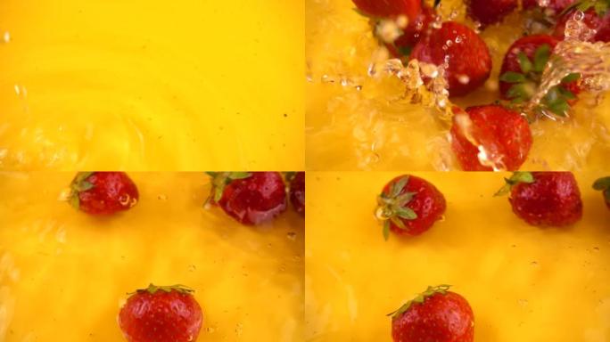 在橙色背景下将草莓掉入水中。慢动作。