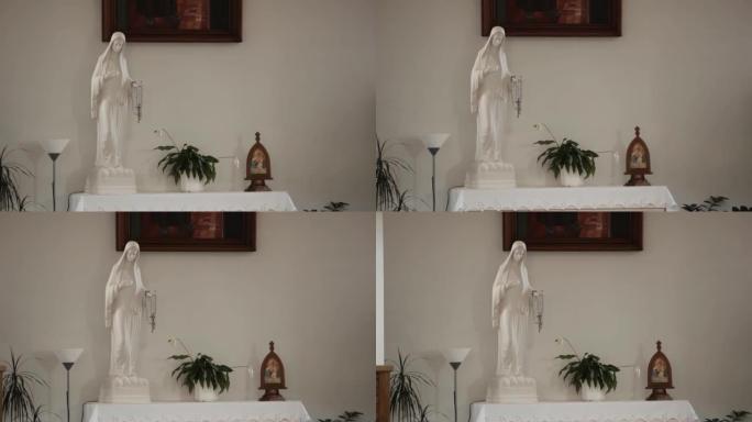 手里拿着念珠的白色圣母玛利亚雕像站在白色基座上