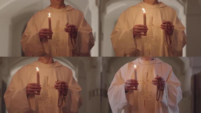 牧师带着燃烧的蜡烛和念珠沿着教堂行走