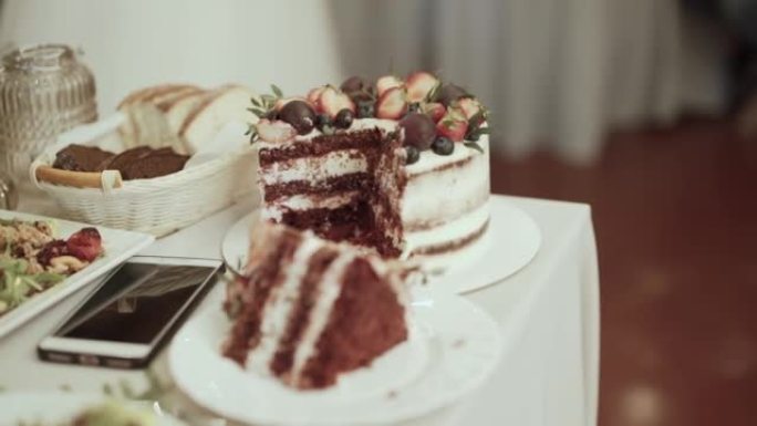 白色和红色馅料的蛋糕，装饰有草莓和巧克力。