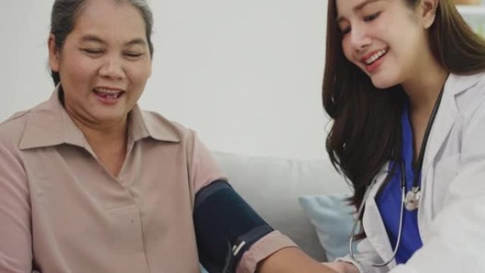 年轻的女护士使用血压计对高级女性患者。