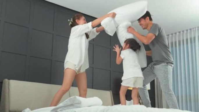 4k视频片段，一个可爱的时刻家庭概念，女儿和父母在家里的卧室里一起玩